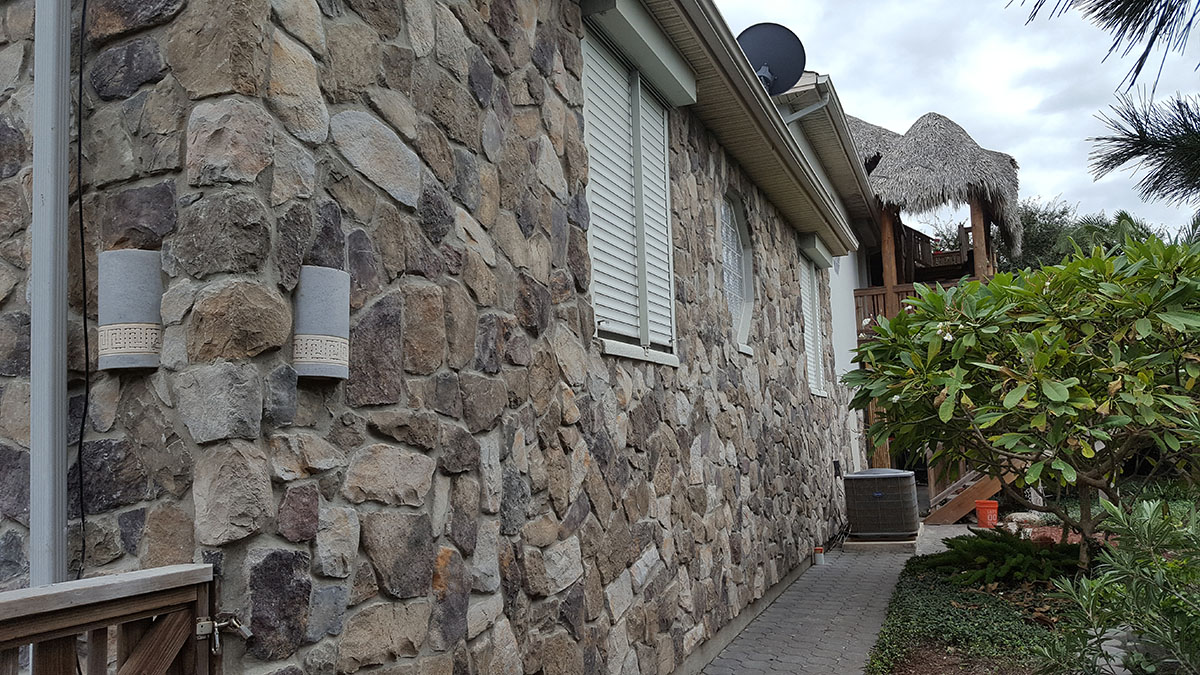 Side of house with stone walls. 